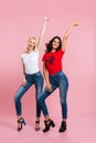 Full length image of two smiling women rejoice in studio Royalty Free Stock Photo