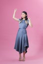 Full length image of young Asian woman wearing blue dress on pink background Royalty Free Stock Photo