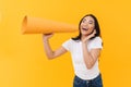 Full length image of young brunette asian woman calling with mouthpiece Royalty Free Stock Photo