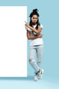 Full length of young woman wearing casual clothes smiling and pointing finger at copyspace isolated over blue background Royalty Free Stock Photo