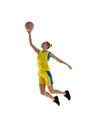 Full-length image of young sportive girl, basketball player in motion, jumping with ball against white studio background Royalty Free Stock Photo