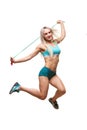 Full length image of a young sports woman jumping on skipping rope over white background Royalty Free Stock Photo