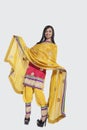 Full length of an Indian woman in salwar kameez standing over gray background Royalty Free Stock Photo