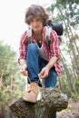 Full length of male backpacker tying shoelace in forest