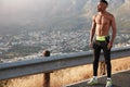 Full length male runner with muscular body, has marathone training, thoughtful expression, admires beautiful panoramic Royalty Free Stock Photo