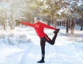 Full length of mature man in sportswear warming up before running outdoors on snowy winter day. Healthy lifestyle Royalty Free Stock Photo