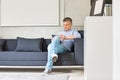 Full-length of Middle-aged man using digital tablet on sofa Royalty Free Stock Photo