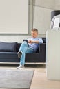 Full-length of Middle-aged man using tablet PC on sofa Royalty Free Stock Photo