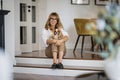 Full length of middle aged woman relaxing at home with her king charles cavalier puppy Royalty Free Stock Photo