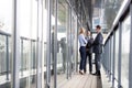 Full length of multi-ethnic business people discussing on office balcony Royalty Free Stock Photo