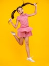 Full length overjoyed teenager kid girl 12 13 14 year jumping old isolated on yellow background studio. Funny jump