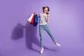 Full length photo of adorable buyer lady dressed casual clothes holding colorful bargains bank card isolated purple