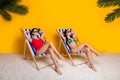 Full length photo of adorable cute ladies wear bikini getting tan arms behind head empty space isolated yellow color Royalty Free Stock Photo