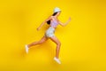 Full length photo of adorable hurrying lady wear striped crop top cap jumping high running fast empty space Royalty Free Stock Photo