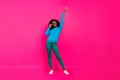 Full length photo of afro american young woman look point finger empty space dancer isolated on pink color background