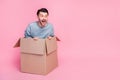 Full length photo of attractive young man sitting inside box excited have fun wear stylish blue garment isolated on pink
