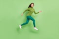 Full length photo of attractive young woman jump up good mood run sale travel dream isolated on green color background
