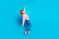 Full length photo of attractive young woman tiptoes falling back dressed stylish pink clothes on blue color