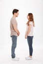 Full length photo of beautiful caucasian couple 20s man and woman wearing beige t-shirts posing together on camera standing face Royalty Free Stock Photo