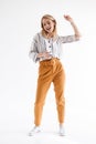 Full length photo of beautiful woman dancing and holding cellphone while listening to music via earpods Royalty Free Stock Photo