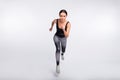 Full length photo of brunette ponytail haired woman jump run endurance sport on grey color background