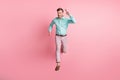 Full length photo of charismatic young man run you jump air charming smile isolated on pastel pink color background