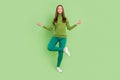 Full length photo of charming calm young woman asana meditation yoga smile isolated on green color background