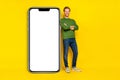 Full length photo of charming handsome guy dressed sweater arms folded modern device empty space isolated yellow color