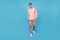 Full length photo of charming happy attractive man walk good mood smile isolated on pastel pink color background
