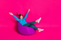 Full length photo of charming young lady wear blue sweater relaxing violet beanbag isolated pink color background Royalty Free Stock Photo