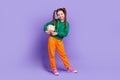 Full length photo of cheerful charming little girl dressed green hoody holding money box isolated purple color Royalty Free Stock Photo