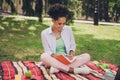 Full length photo of cheerful happy dark skin woman smile write note student sit grass outside in part outdoors