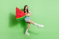 Full length photo of cheerful happy pretty young woman hold big watermelon slice isolated on green color background Royalty Free Stock Photo