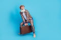 Full length photo of cheerful man pensioner wear checkered costume rising heavy baggage empty space isolated blue color