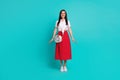 Full length photo of cheerful shiny lady dressed white crop top purse smiling walking isolated turquoise color