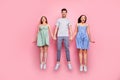 Full length photo of cheerful youngsters enjoying jumping wearing striped t-shirt pants trousers isolated over pink