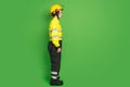 Full length photo of confident pretty firewoman dressed yellow uniform helmet looking empty space isolated green color