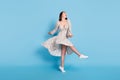 Full length photo of cool brown hairdo young lady dance wear dress isolated on blue background