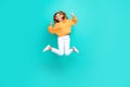 Full length photo of cool funky school girl dressed orange hoodie jumping high showing hard rock listening songs Royalty Free Stock Photo