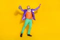 Full length photo of cool pretty man wear purple velvet jacket having fun rising discotheque ball isolated yellow color