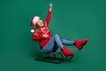 Full length photo of cool young lady sled wear new year pullover cap jeans boots on green color background