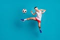 Full length photo of crazy football player kick ball in jump wear white tank-top isolated over blue color background