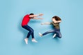 Full length photo of crazy mad two people spouses woman disagree jump fight kick man fall wear green red t-shirt denim Royalty Free Stock Photo