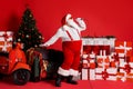 Full Length Photo Of Crazy Santa Claus Sing Song In Mic Isolated On Red Shine Color Background With X-mas Stockings