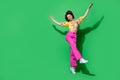 Full length photo of cute charming girl dressed off shoulders top jumping high walking empty space isolated green color Royalty Free Stock Photo