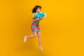 Full length photo of cute funky lady wear flower print clothes jumping high shooting money gun empty space isolated Royalty Free Stock Photo