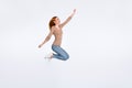 Full length photo of cute funny ginger lady wear beige shirt smiling jumping high like hero isolated white color