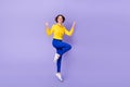 Full length photo of cute millennial brunette lady jump v-sign wear shirt pants sneakers isolated on purple background Royalty Free Stock Photo