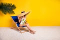 Full length photo of cute shy lady wear swimsuit enjoying sun bathing lounge chair empty space isolated yellow color Royalty Free Stock Photo