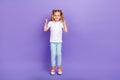 Full length photo of cute small girl tails raise fists jump win competition wear stylish white blouse isolated on violet